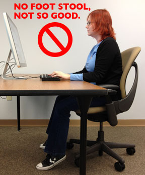 Woman working on computer at desk without foot stool, only toes touching the ground.